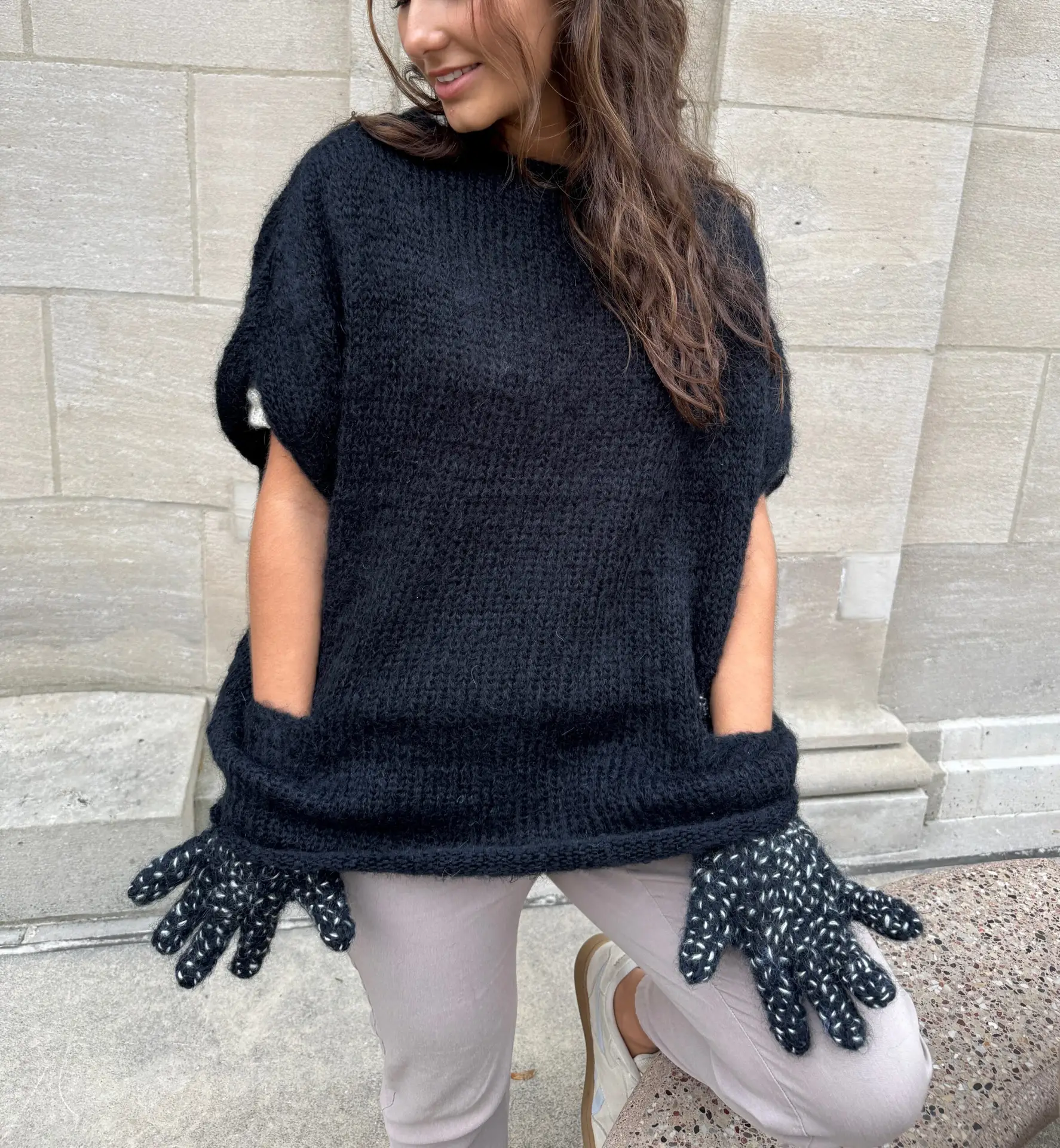 black hand-knitted mohair cape with build-in-glove pockets by New York designer